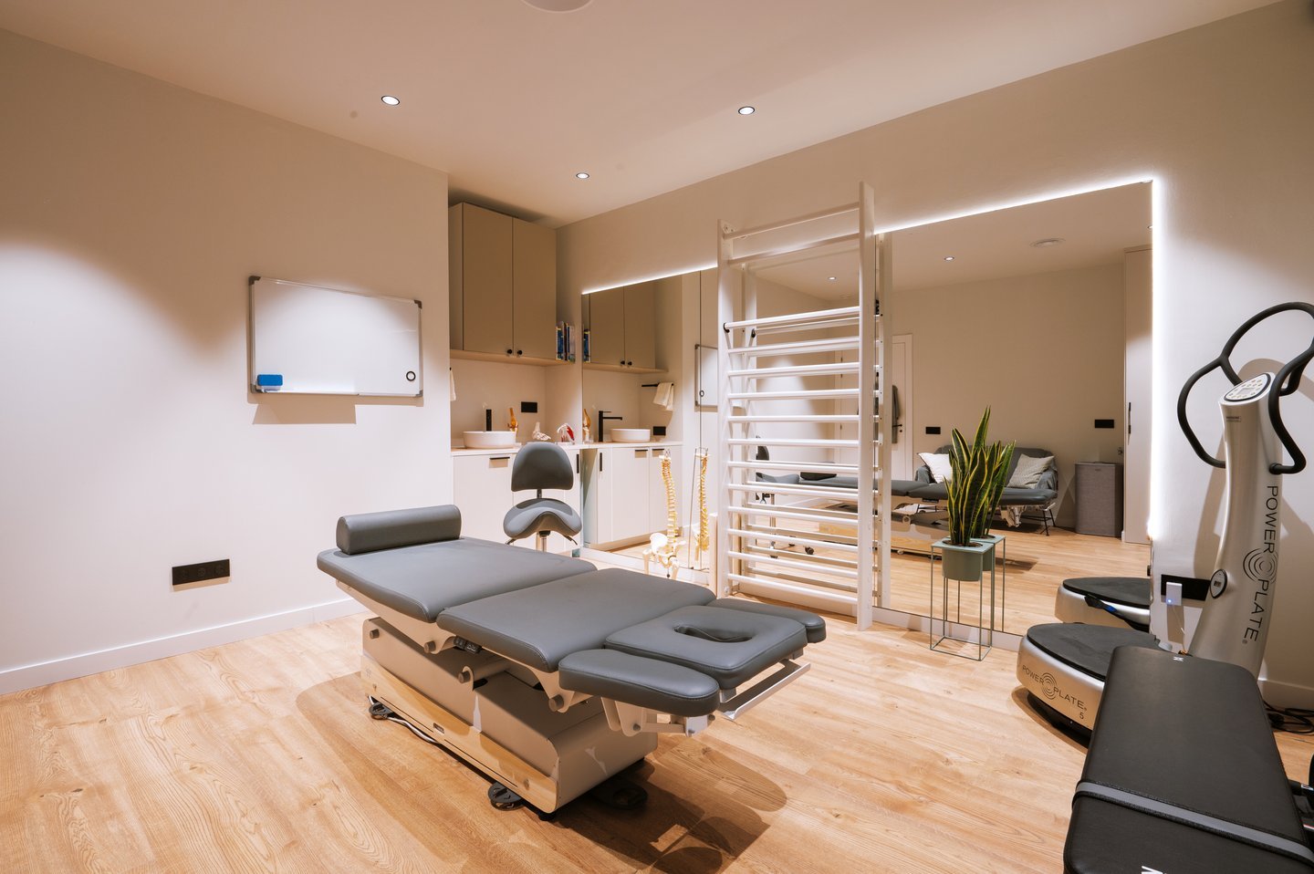 Cabina principal de fisioteràpia de Physio Wellness by Marshall a Sitges, amb llitera articulada hidràulica, espatllera i mirall retroil·luminat.