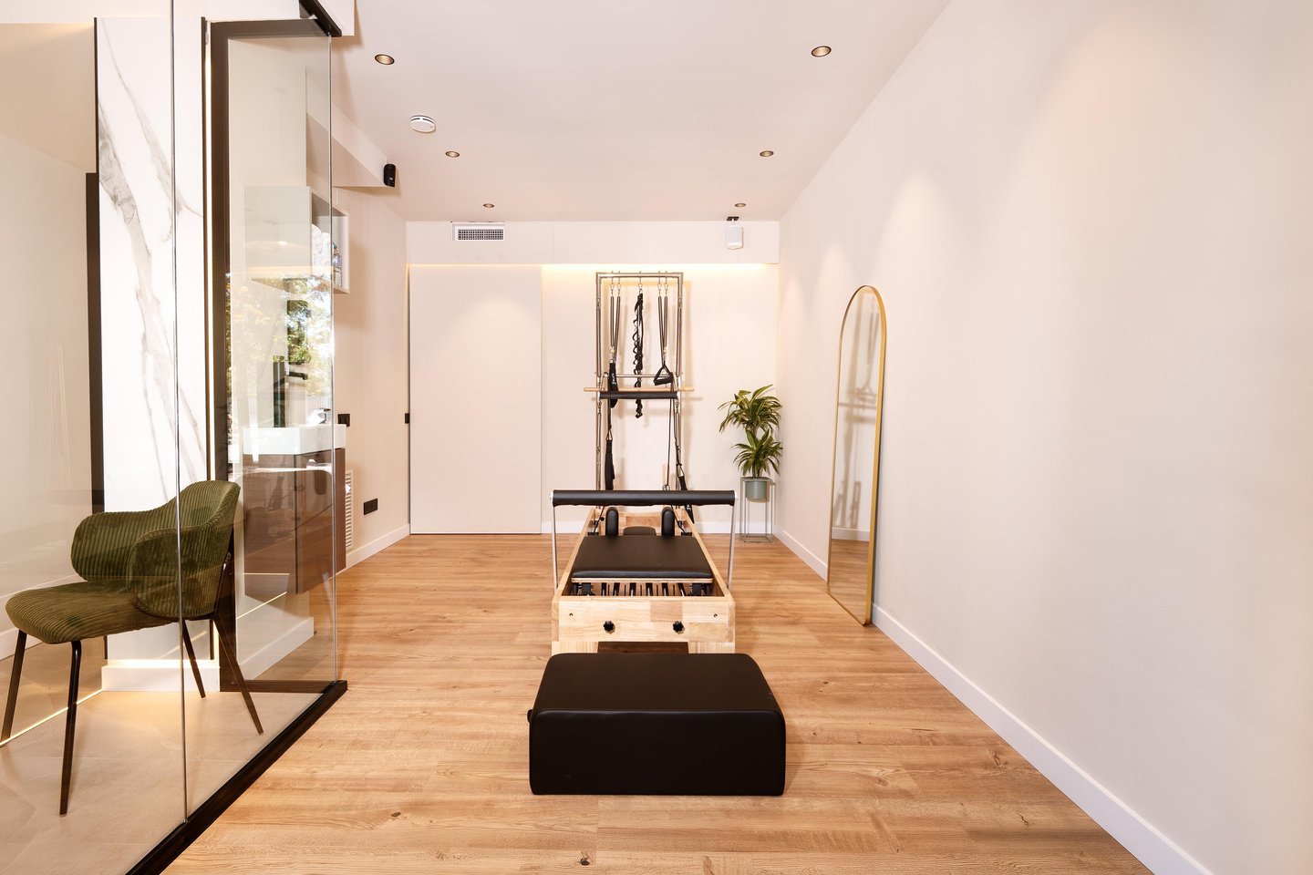 Estudi de Pilates Reformer amb màquina de fusta Pilatu, torre i mirall d'arc a Physio Wellness by Marshall.